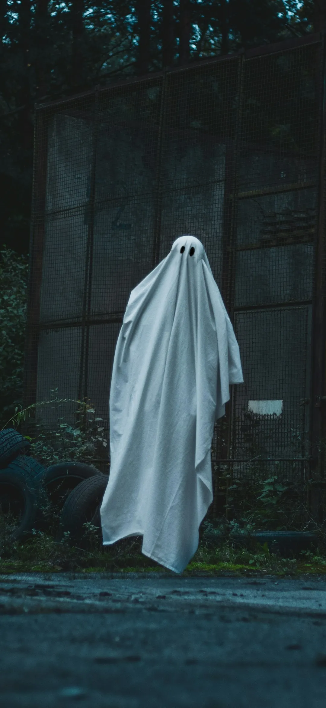 White ghost in front of a building Halloween wallpaper