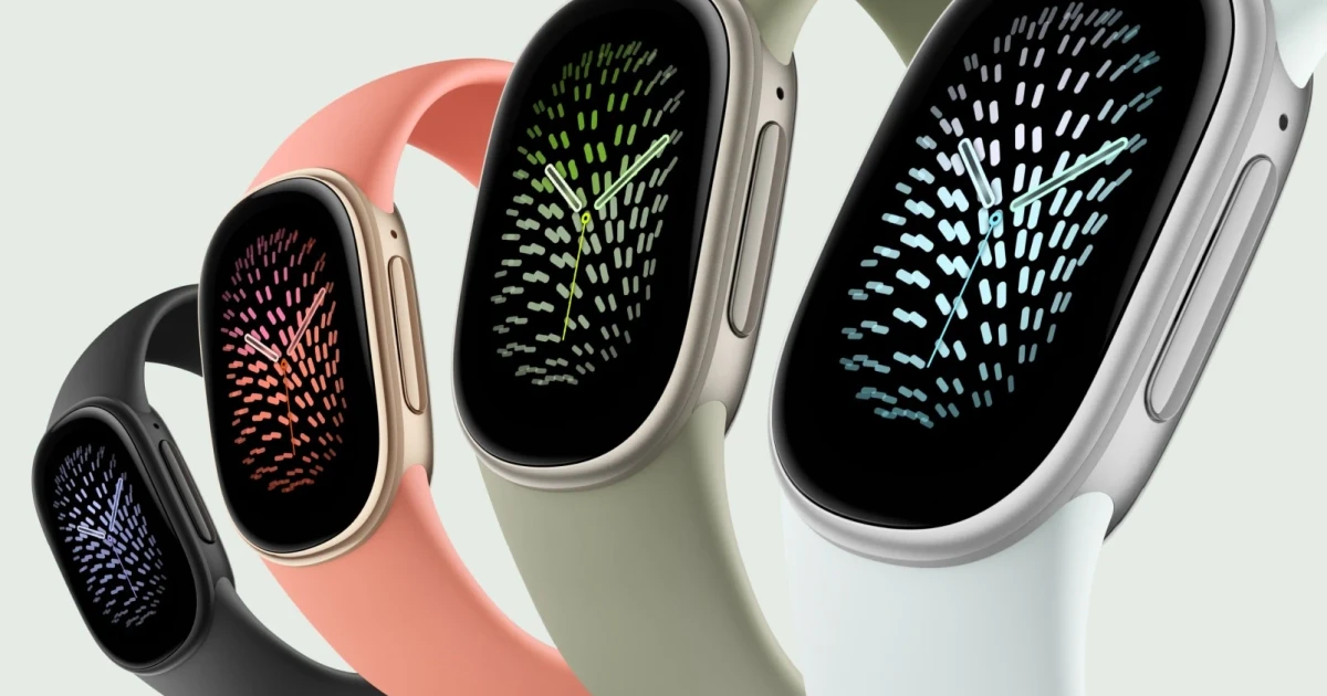 Four Google Fitbit Edge trackers in black, coral, sage, and white bands showing analog clock faces