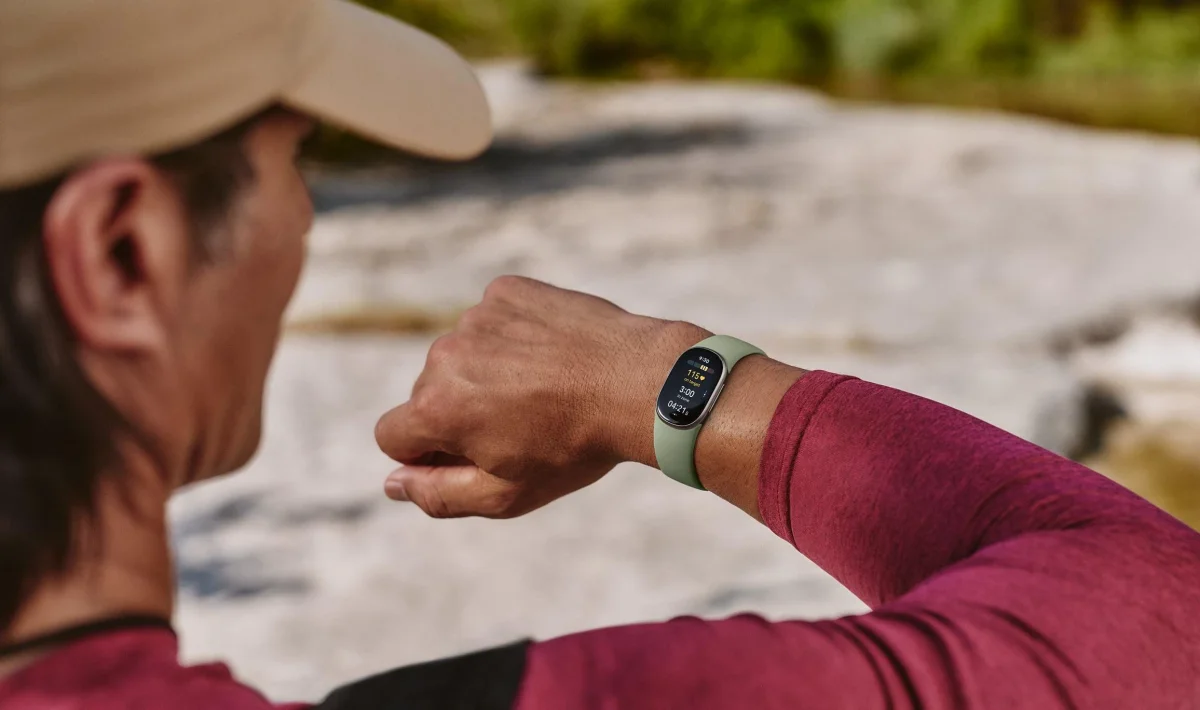 Person checking a Fitbit Edge on their wrist during a hike